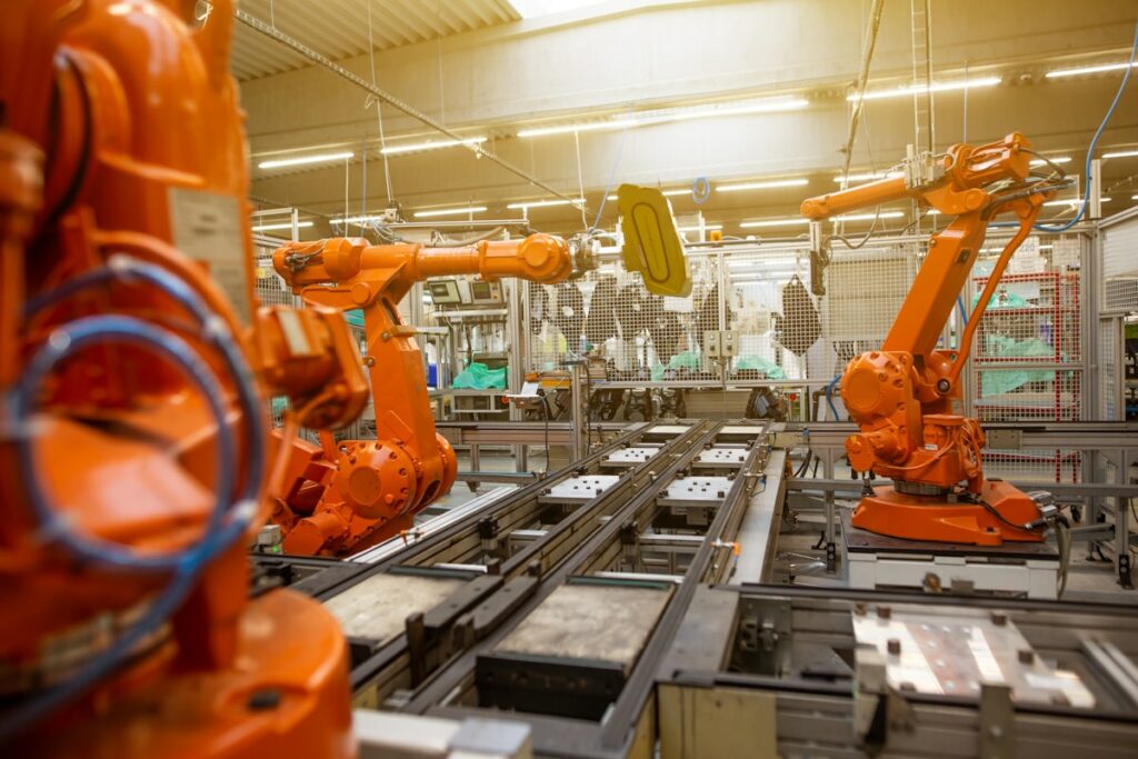 Ramiona robotów przemysłowych na linii produkcyjnej - automatyzacja produkcji