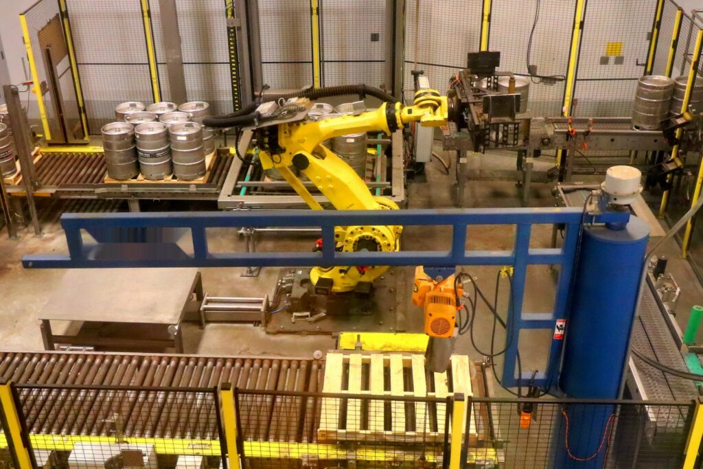 Robotic palletising of heavy steel beer kegs – units moved two at a time from the conveyor onto a pallet inside a guarded cell