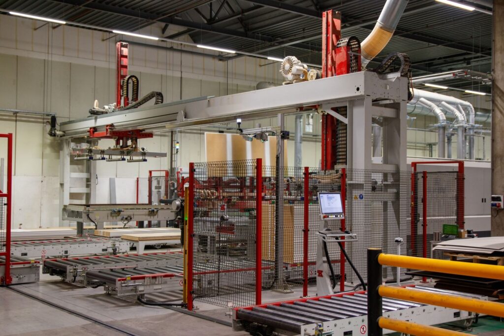 Automated panel palletising station with a vacuum gripper, roller conveyors, safety guarding and an HMI panel